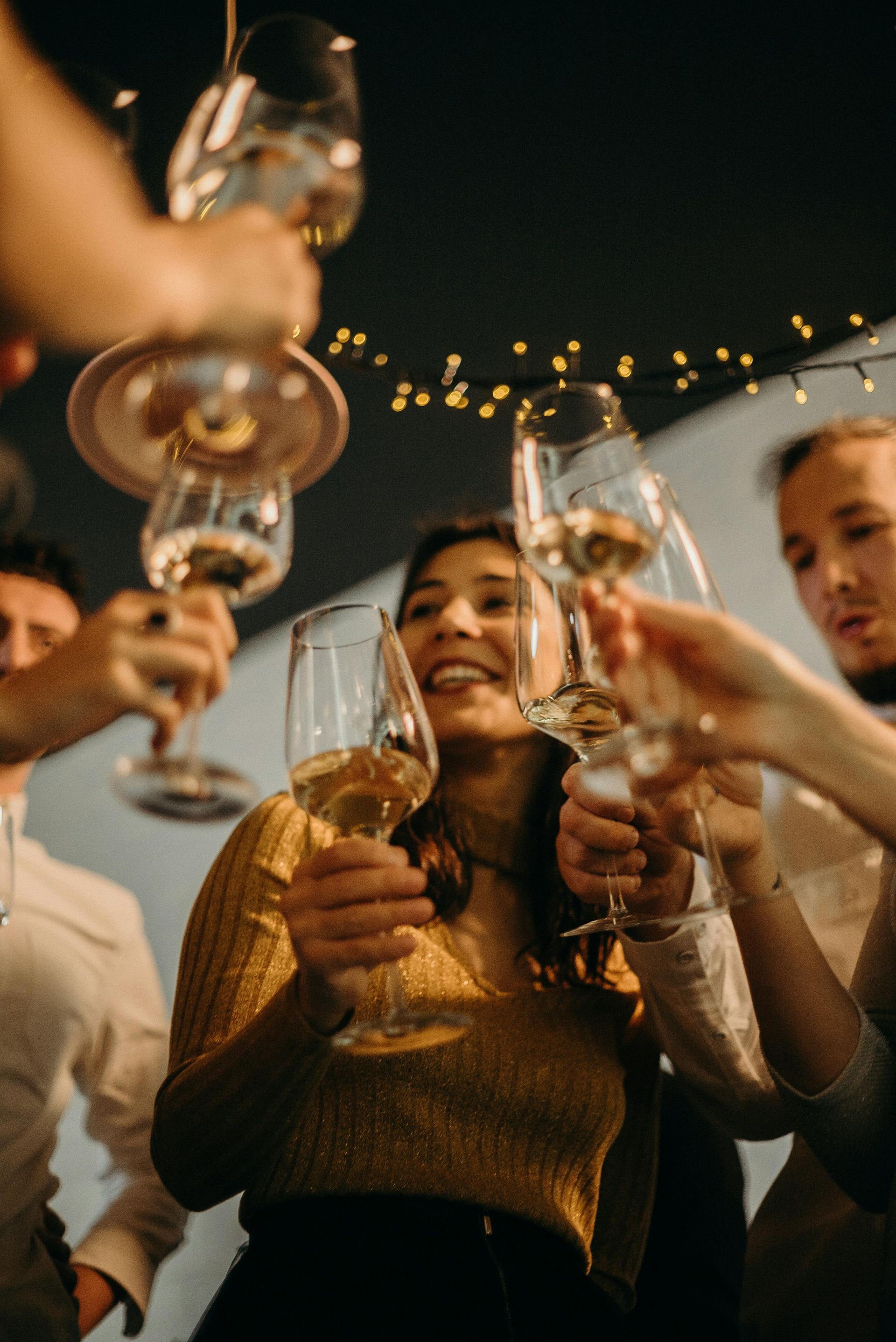 People toasting with wine glasses, celebratory atmosphere.