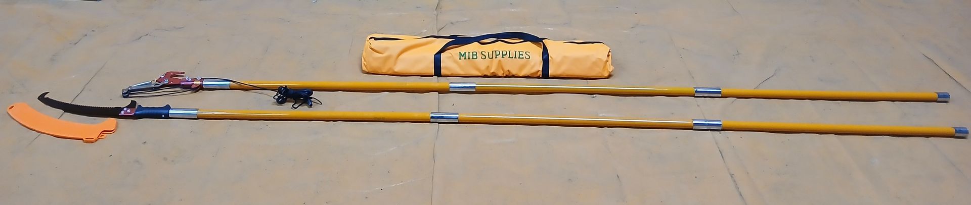 A set of orange and yellow utility poles with an orange bag on a light brown surface. A set of orange and yellow utility poles with an orange bag on a light brown surface.