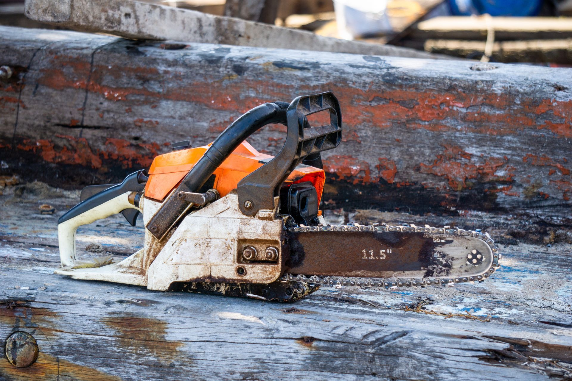 A chainsaw is sitting on a piece of wood.