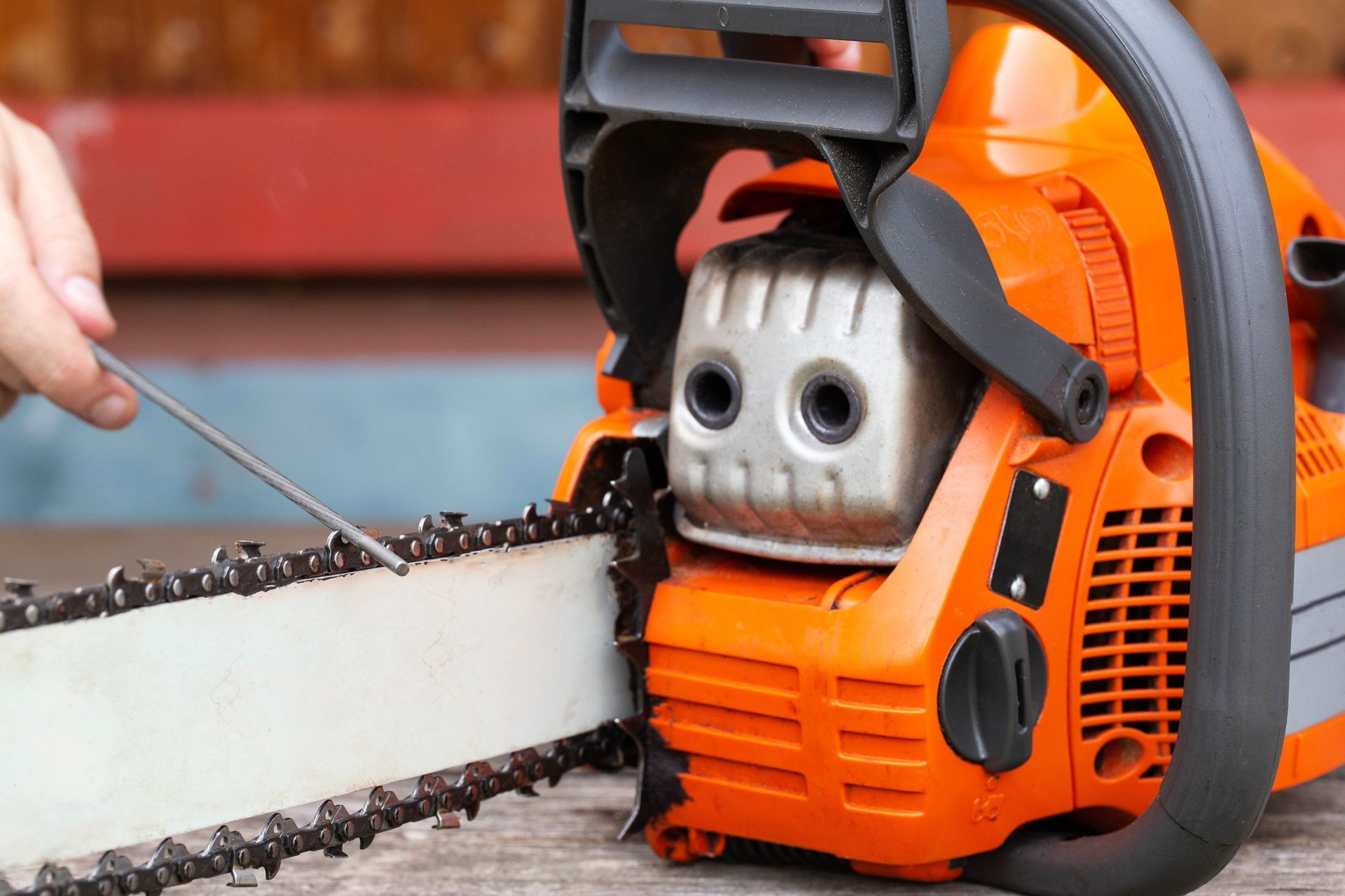A person is using a chainsaw to cut a piece of wood.