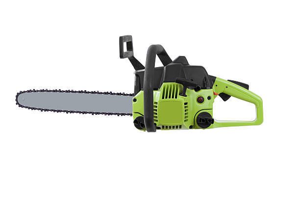 A green chainsaw is sitting on a white surface.