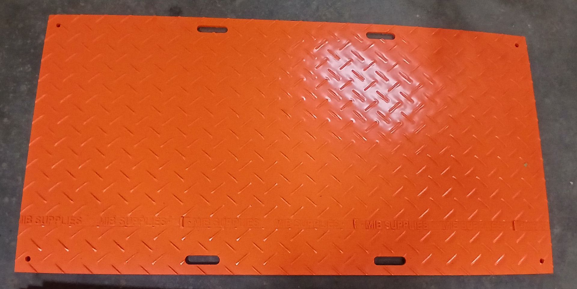 Orange metal plate with diamond pattern and slots, likely for flooring.
