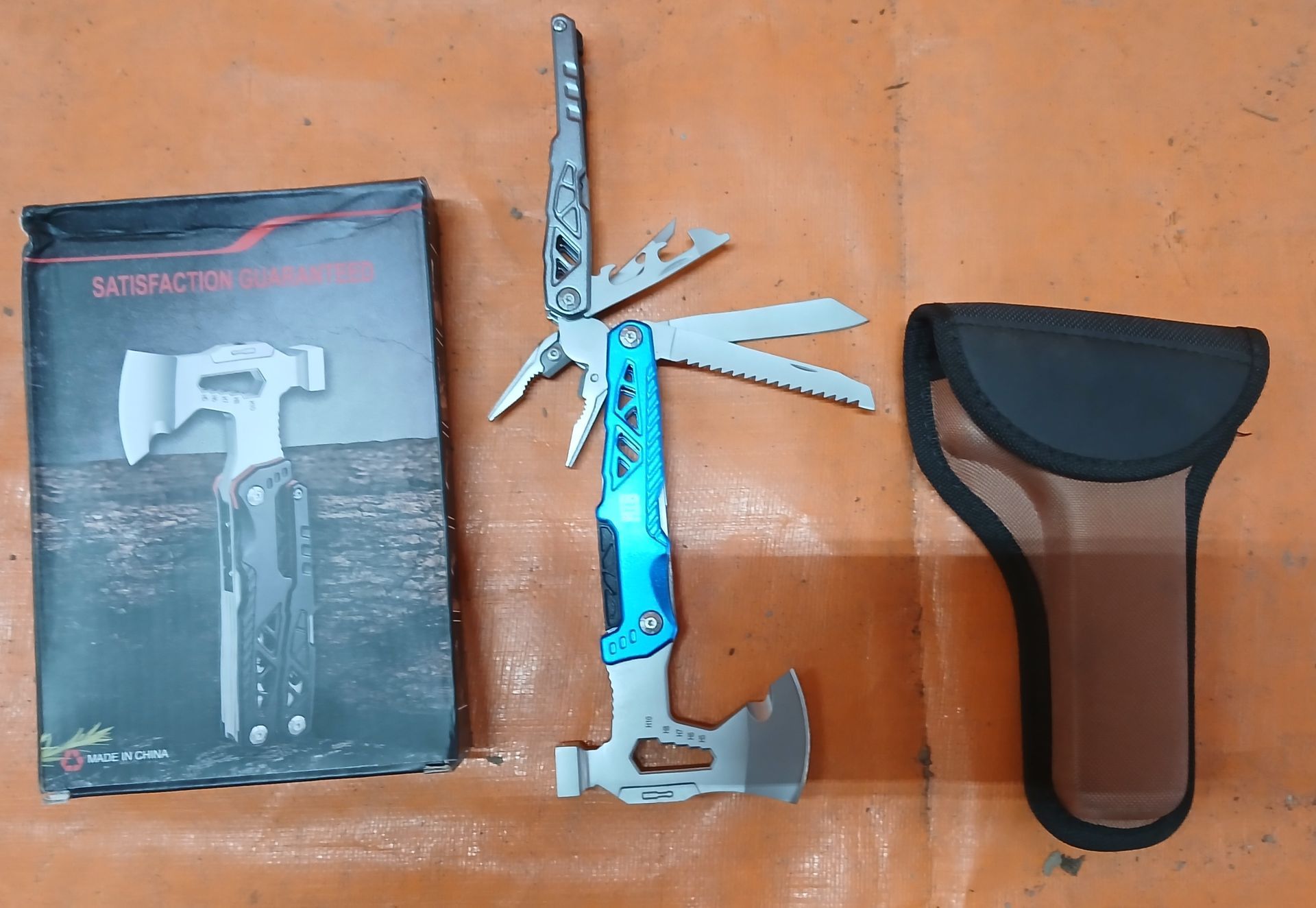 Multi-tool with case and box on a brown surface. Multi-tool with case and box on a brown surface.