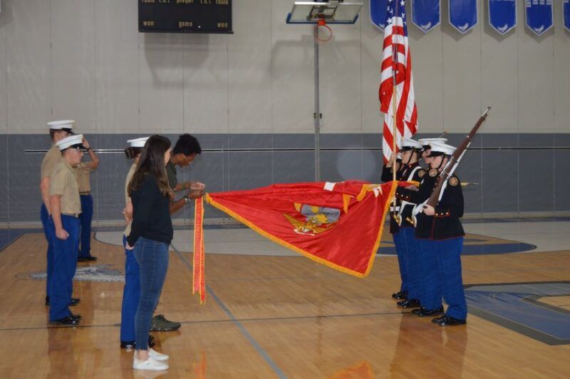 A group of people holding a flag in a gym
