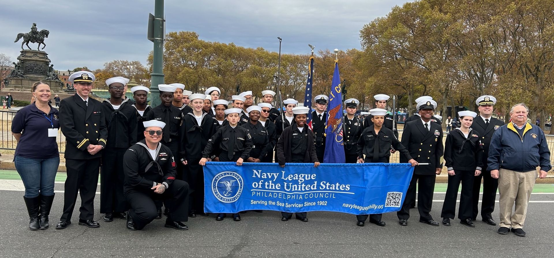 A group of people in military uniforms are holding a blue banner