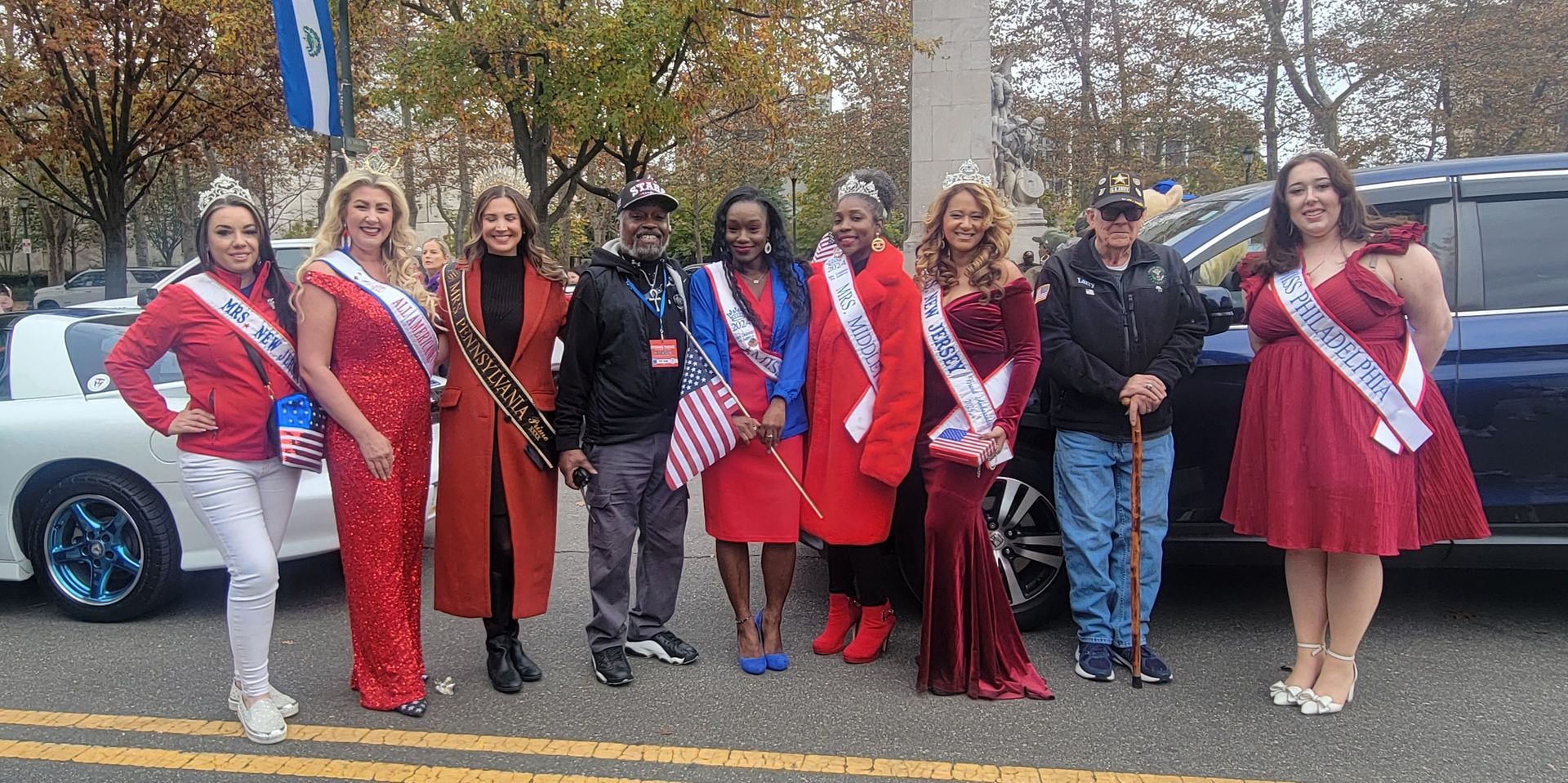 A group of people standing next to each other in front of a car