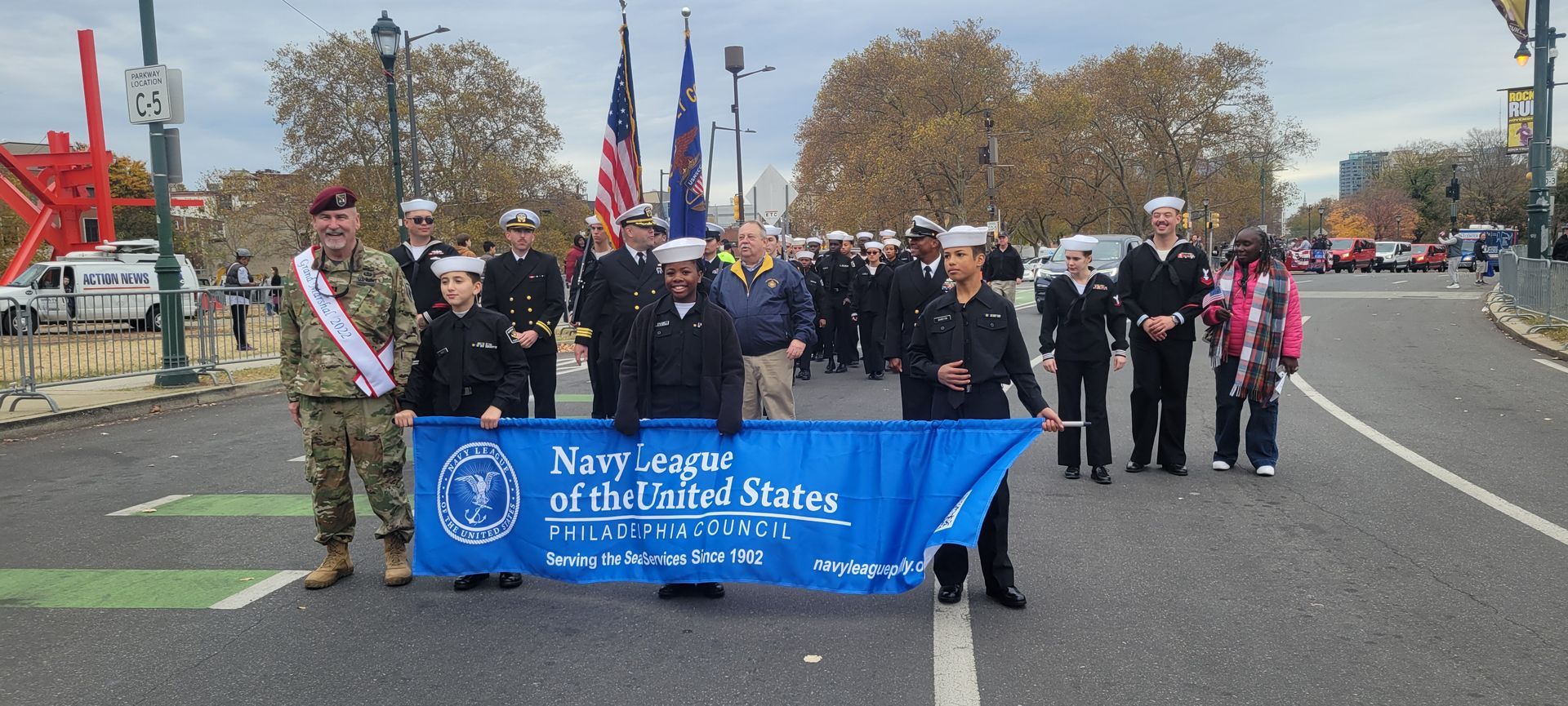 A group of people are holding a blue banner that says navy legacy of the united states