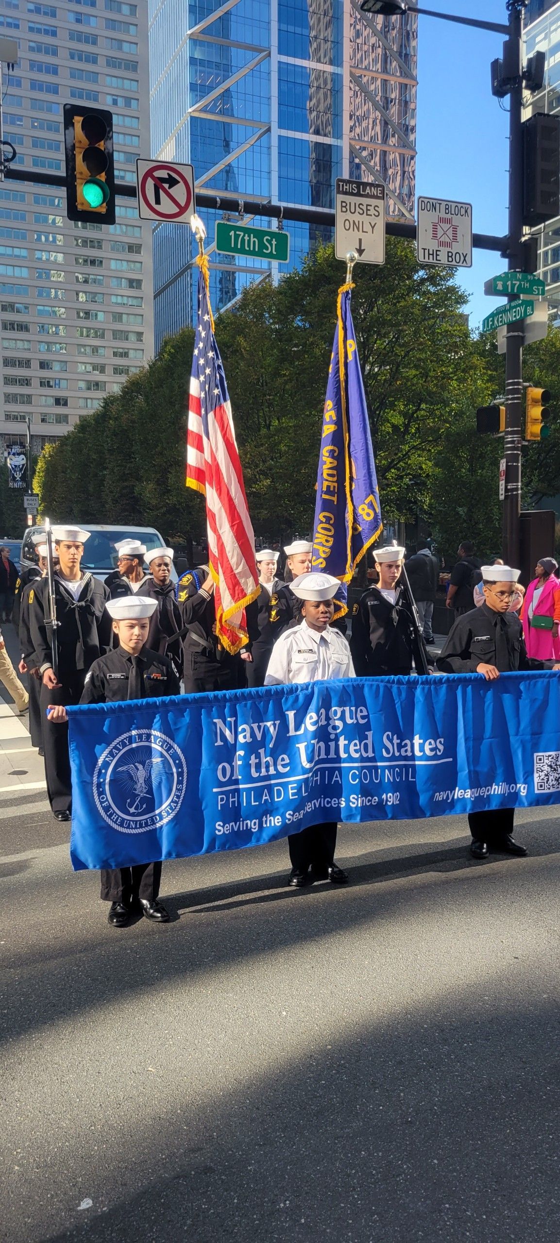 A group of people are marching down a street holding flags