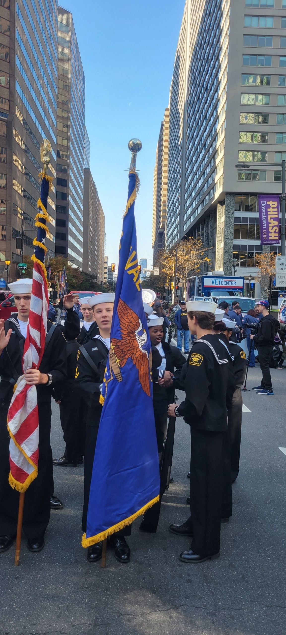 A group of people are holding a blue banner that says navy league of the united states.