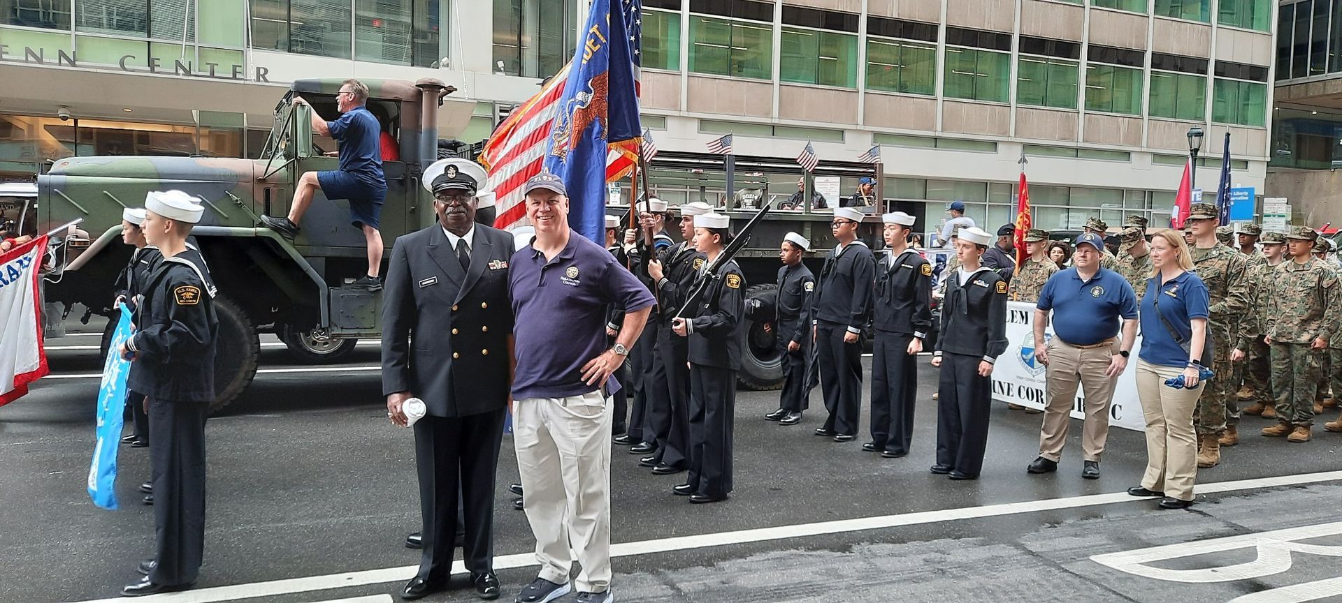 A group of people standing in front of a military vehicle