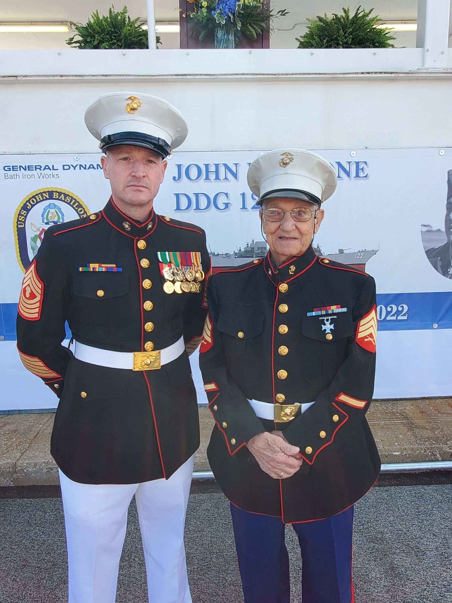 Two men in military uniforms are standing next to each other