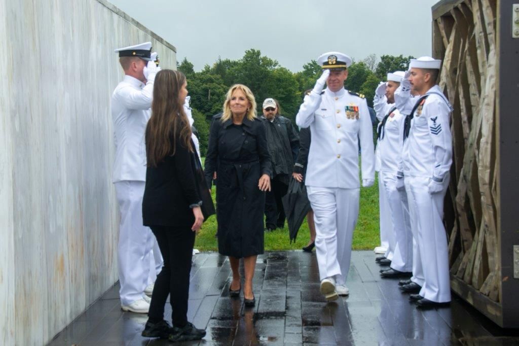 A group of people in military uniforms are walking down a sidewalk.