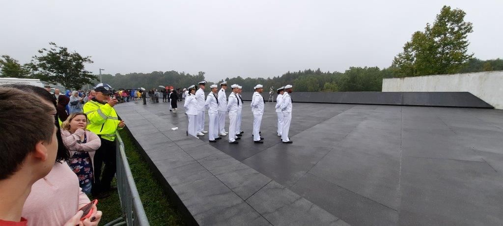 A group of men in white uniforms are standing in a line.