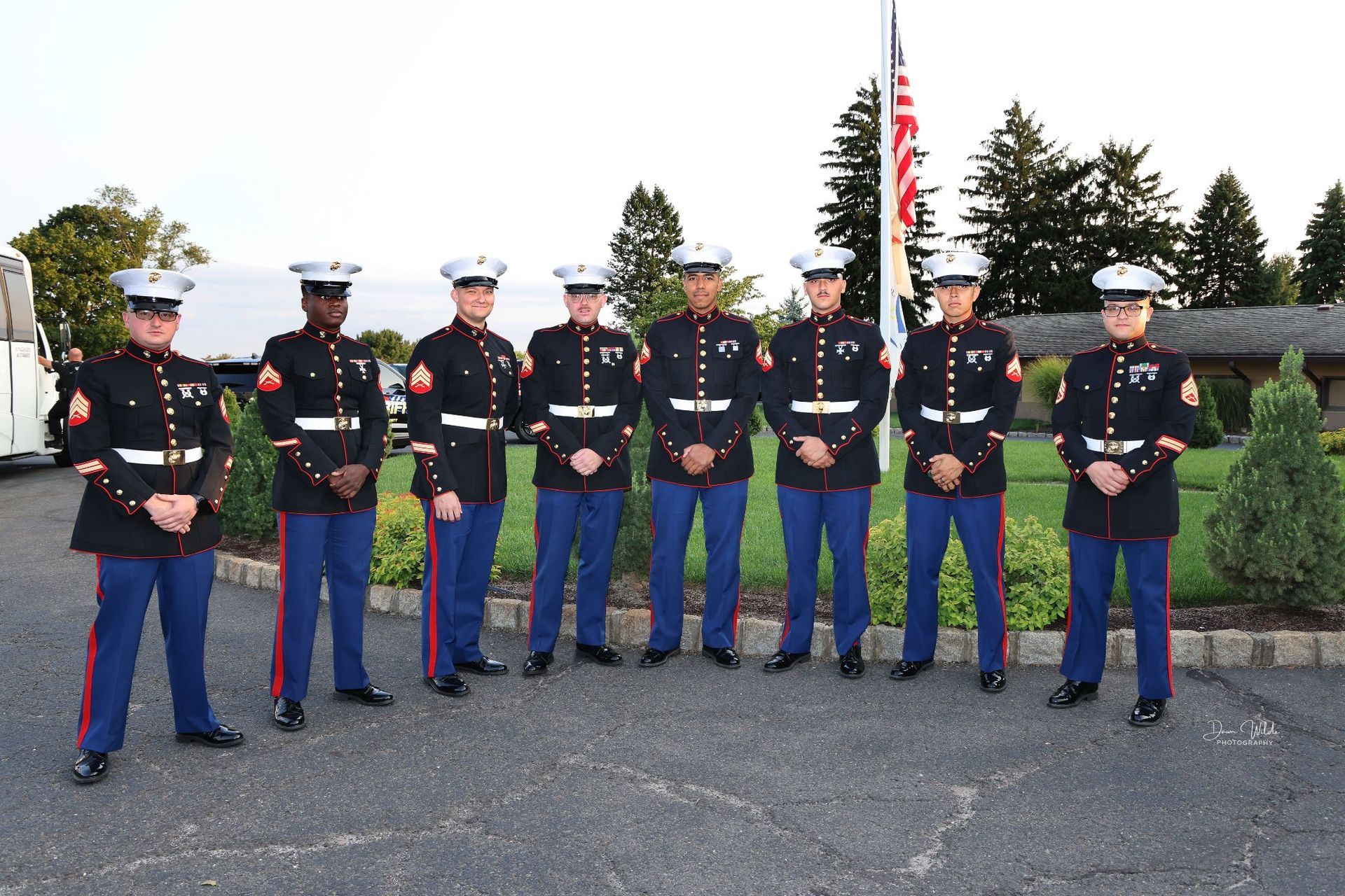 A group of marines standing in front of an american flag