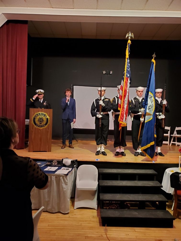 A group of people standing on a stage holding flags