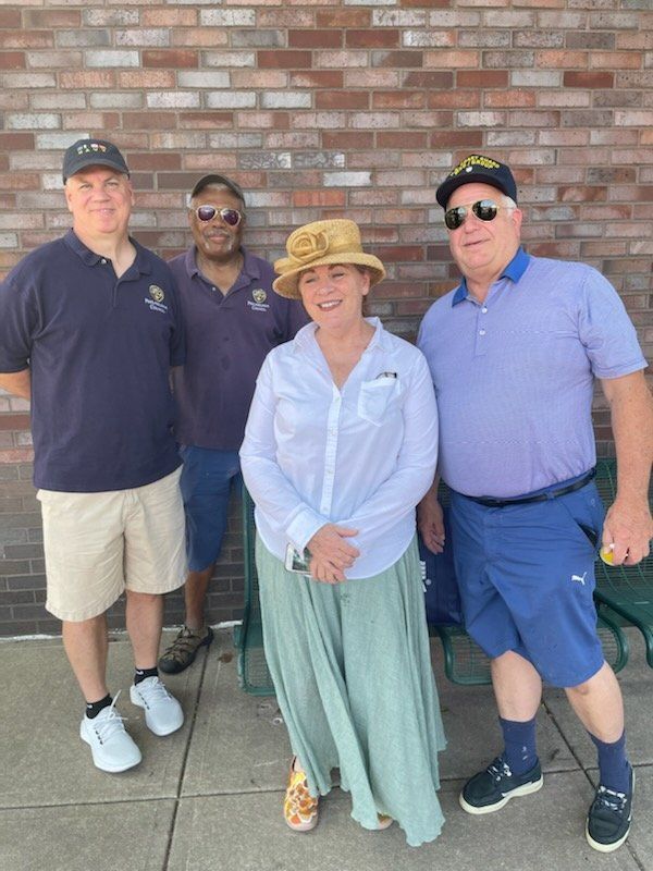 A group of people are posing for a picture in front of a brick wall.