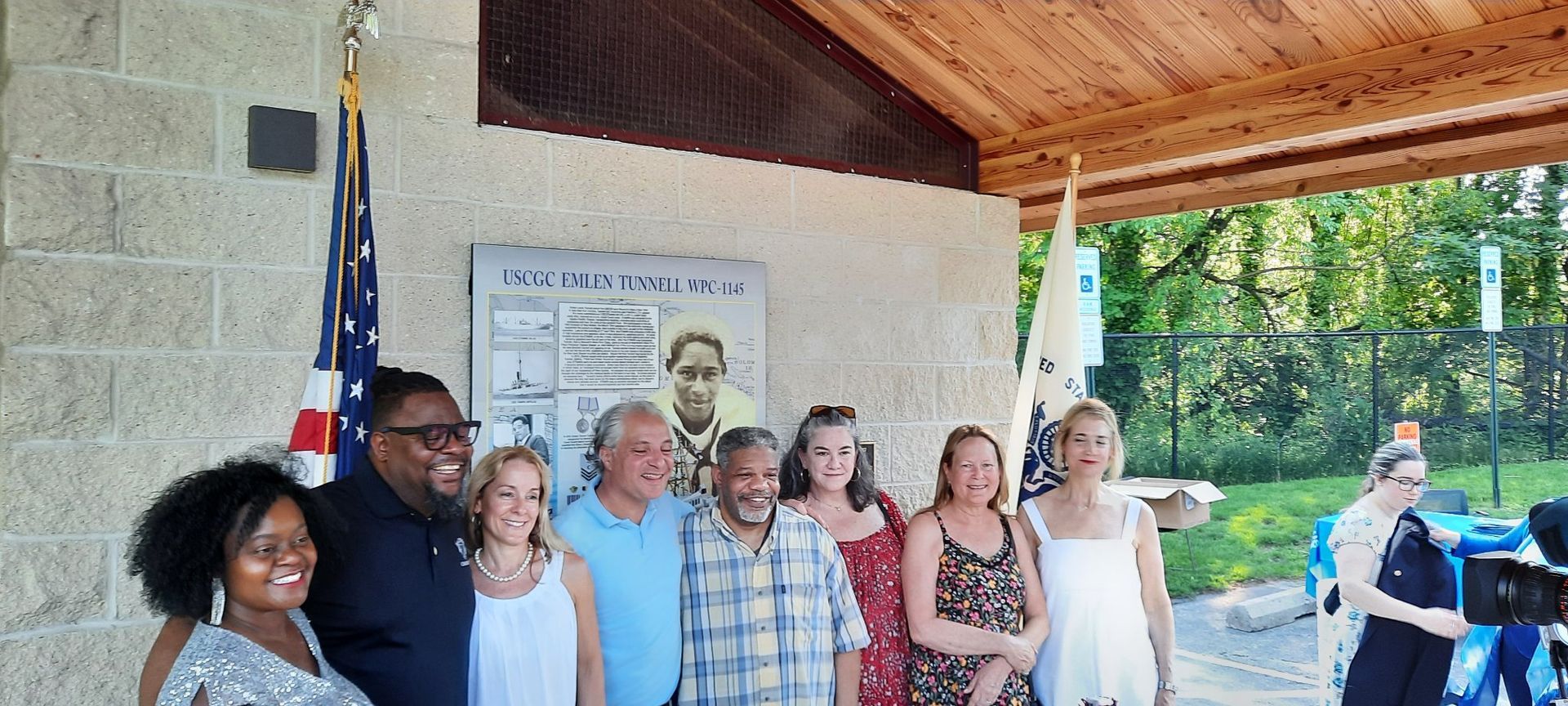 A group of people are posing for a picture under a pavilion.
