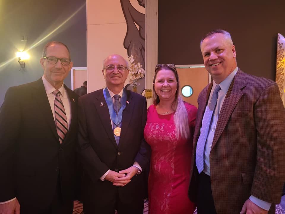 A group of men and a woman are posing for a picture.