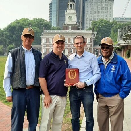 A group of men standing next to each other holding a book