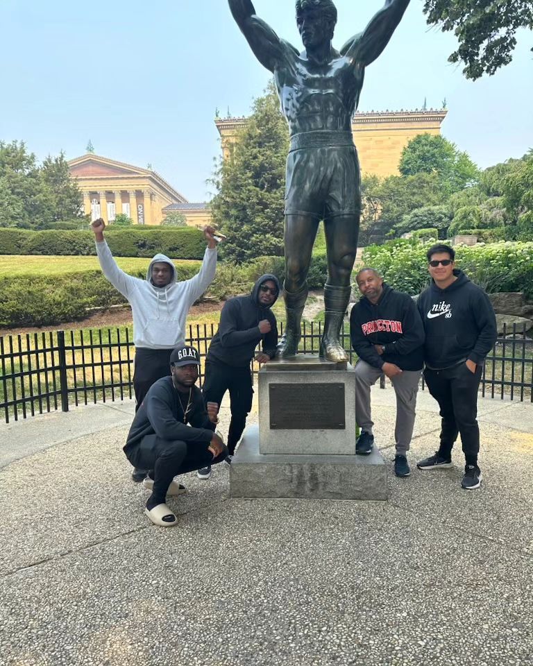 A group of men are posing for a picture in front of a statue