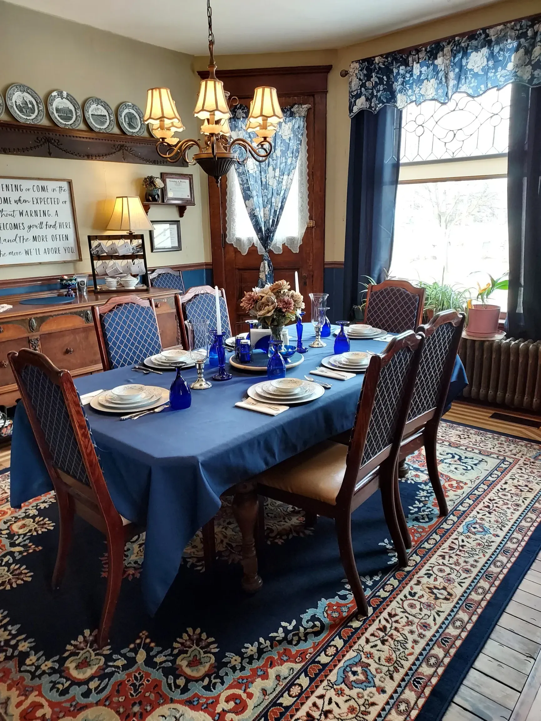 A dining room with a table and chairs set for a meal.