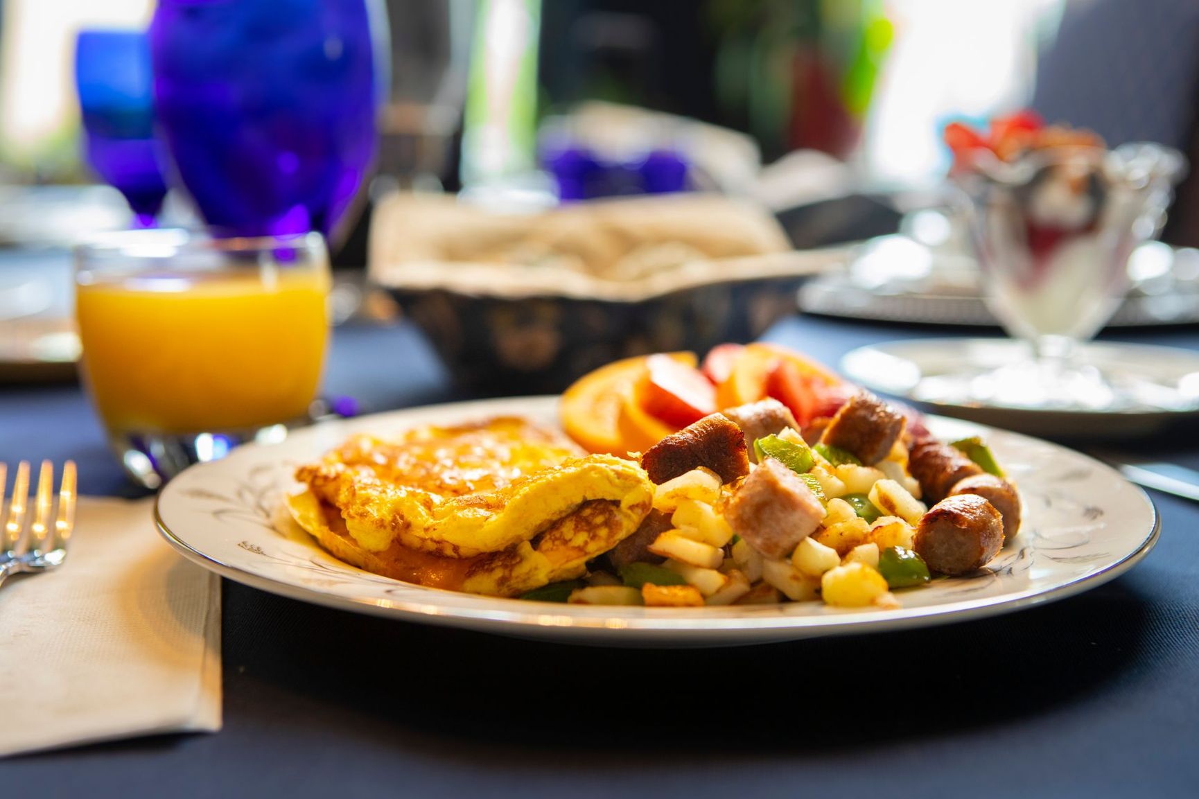 A plate of food is sitting on a table next to a glass of orange juice.