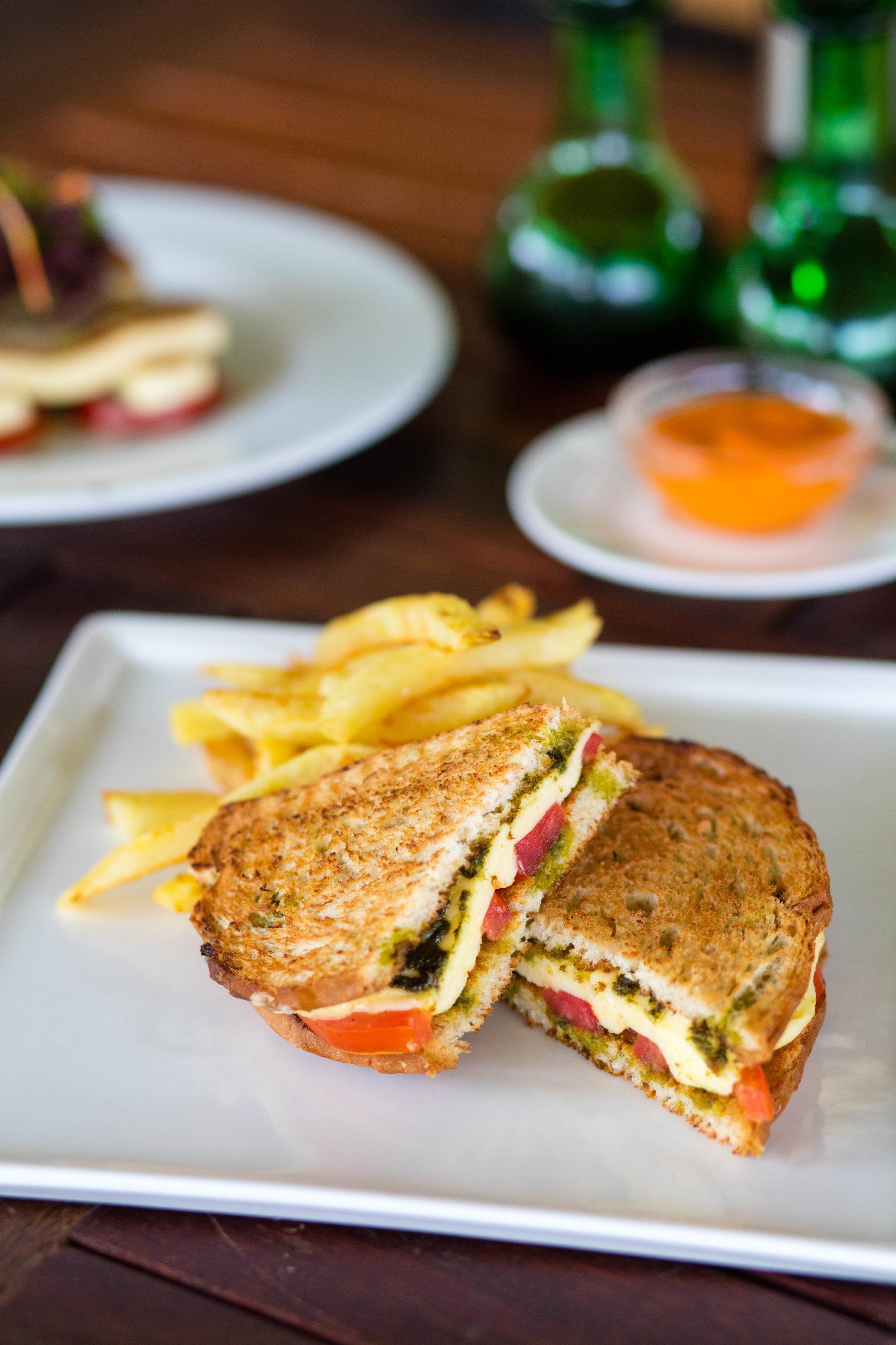 A grilled sandwich with french fries on a white plate.
