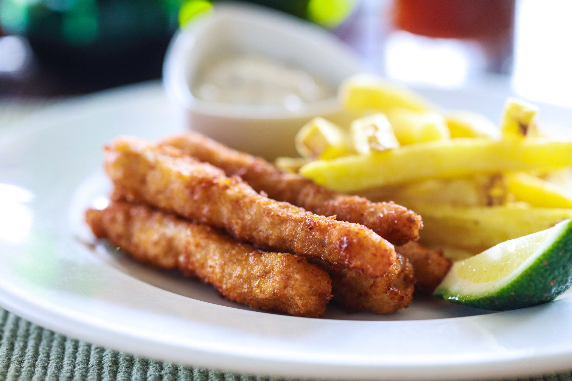 A white plate topped with fried fish and french fries
