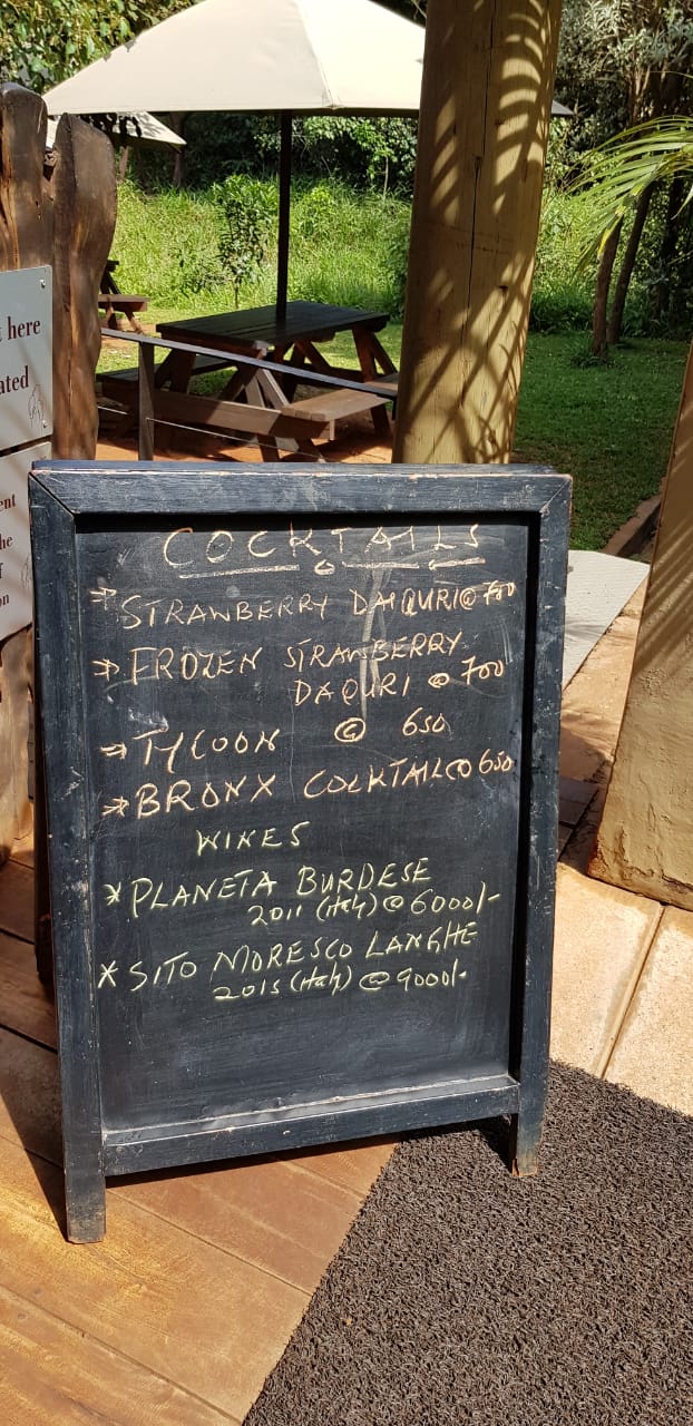 A blackboard with a menu on it is sitting on a wooden floor.