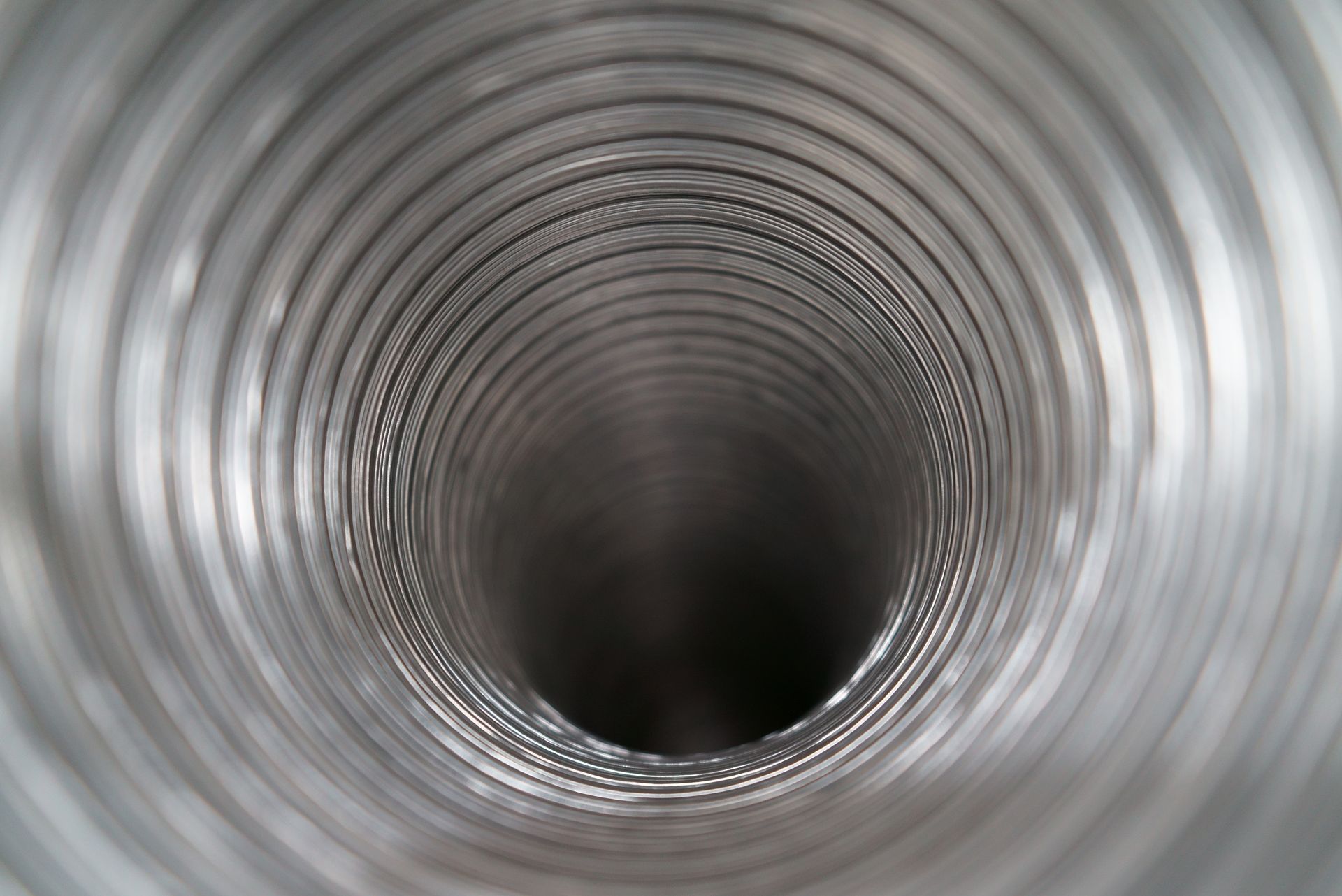 Inside view of a metallic, flexible duct with spiraling ridges.
