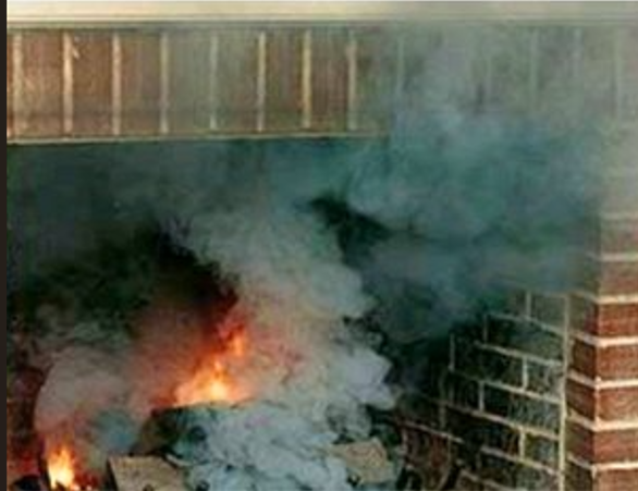 Chimney sweep on a roof, cleaning the chimney with a brush against a blue sky.