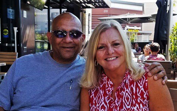 A man and a woman are posing for a picture at a restaurant.