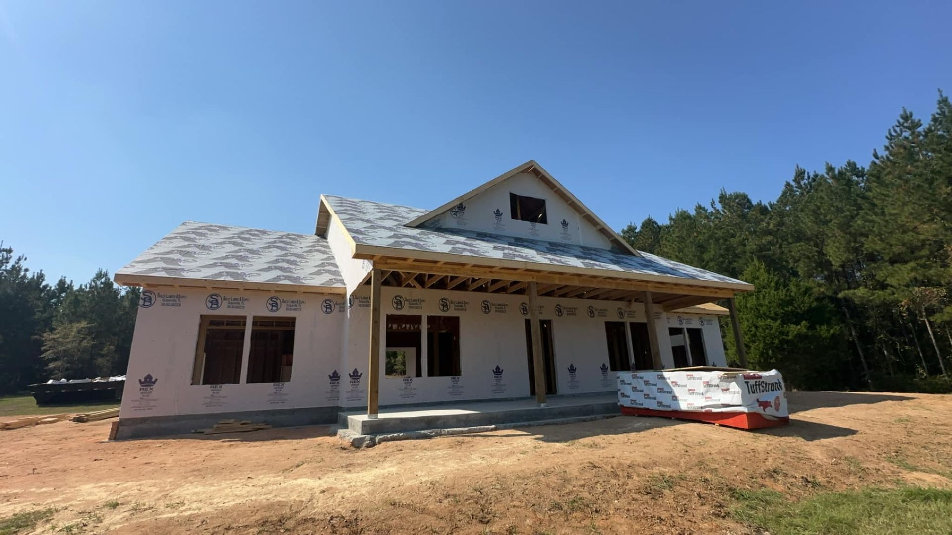 A house is being built in the middle of a dirt field.