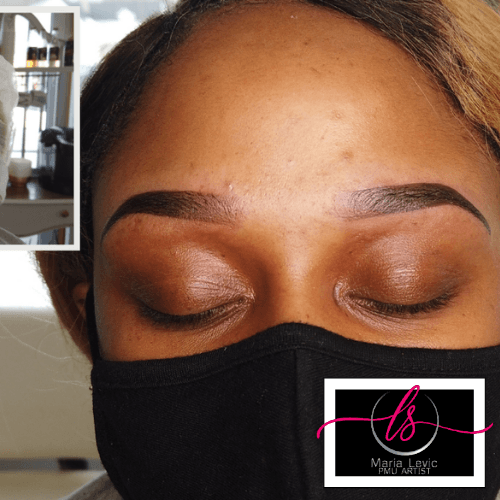 Person with closed eyes, wearing a black face mask, showcasing newly done, dark brown eyebrows.