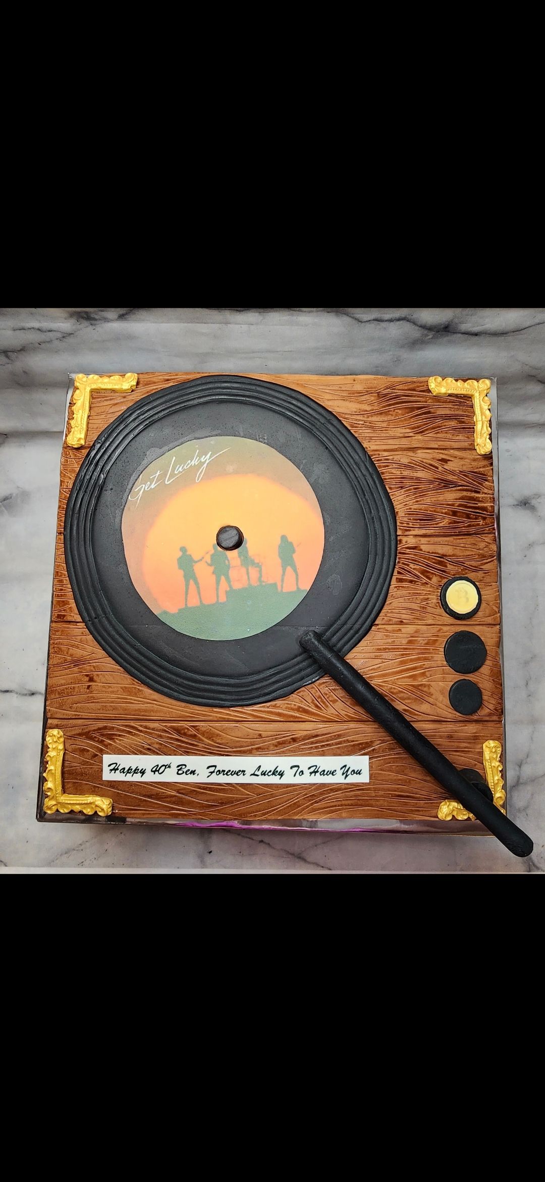 A cake in the shape of a record player with a magnifying glass on it.