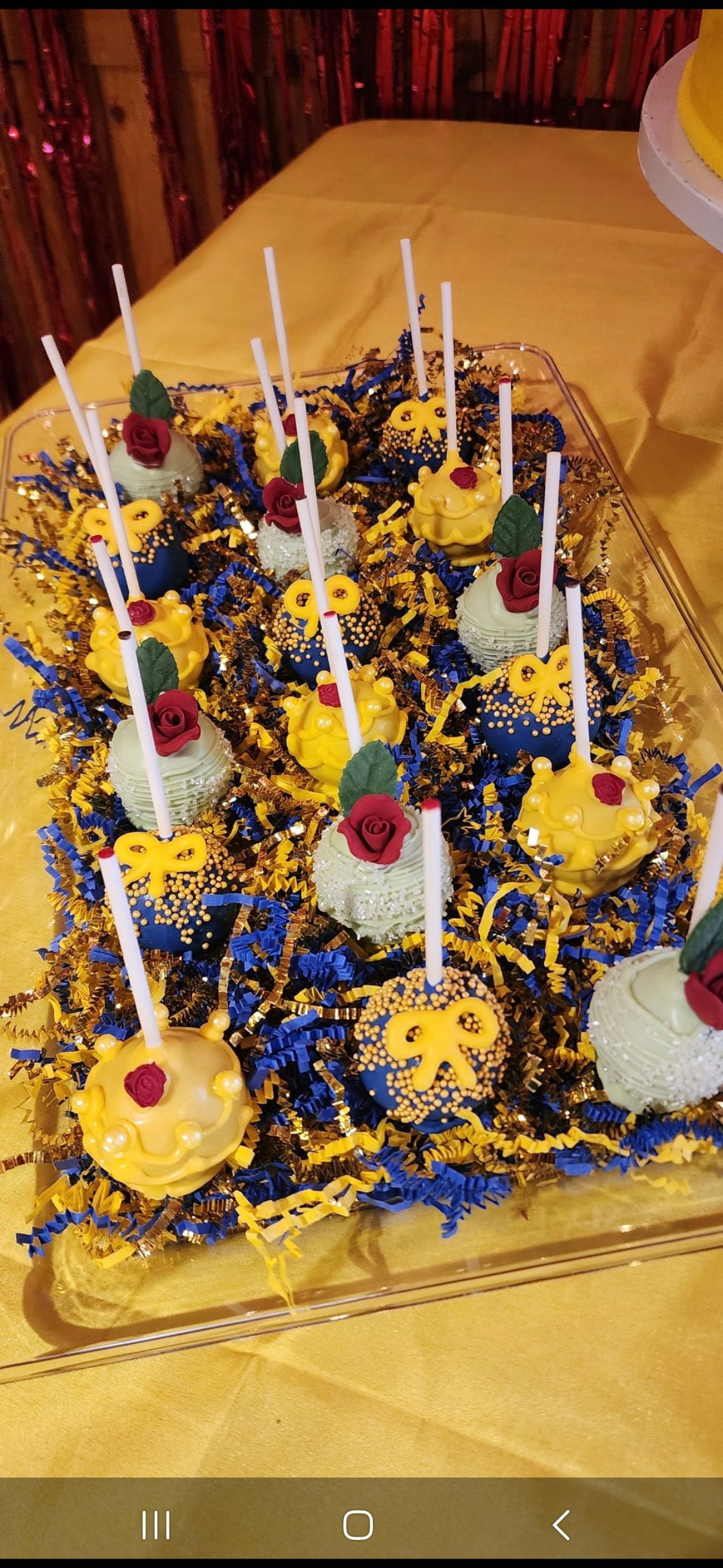 A bunch of cake pops on a tray on a table.