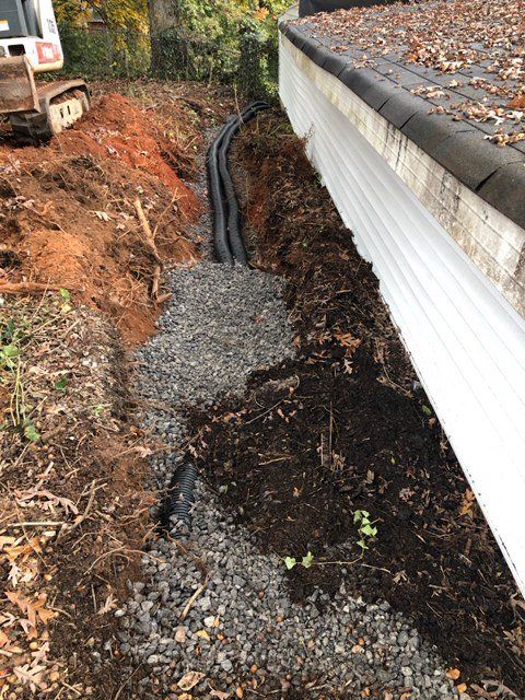 a bulldozer is digging a hole in the ground next to a house .