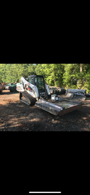 a bulldozer is sitting on top of a pile of dirt in a parking lot .