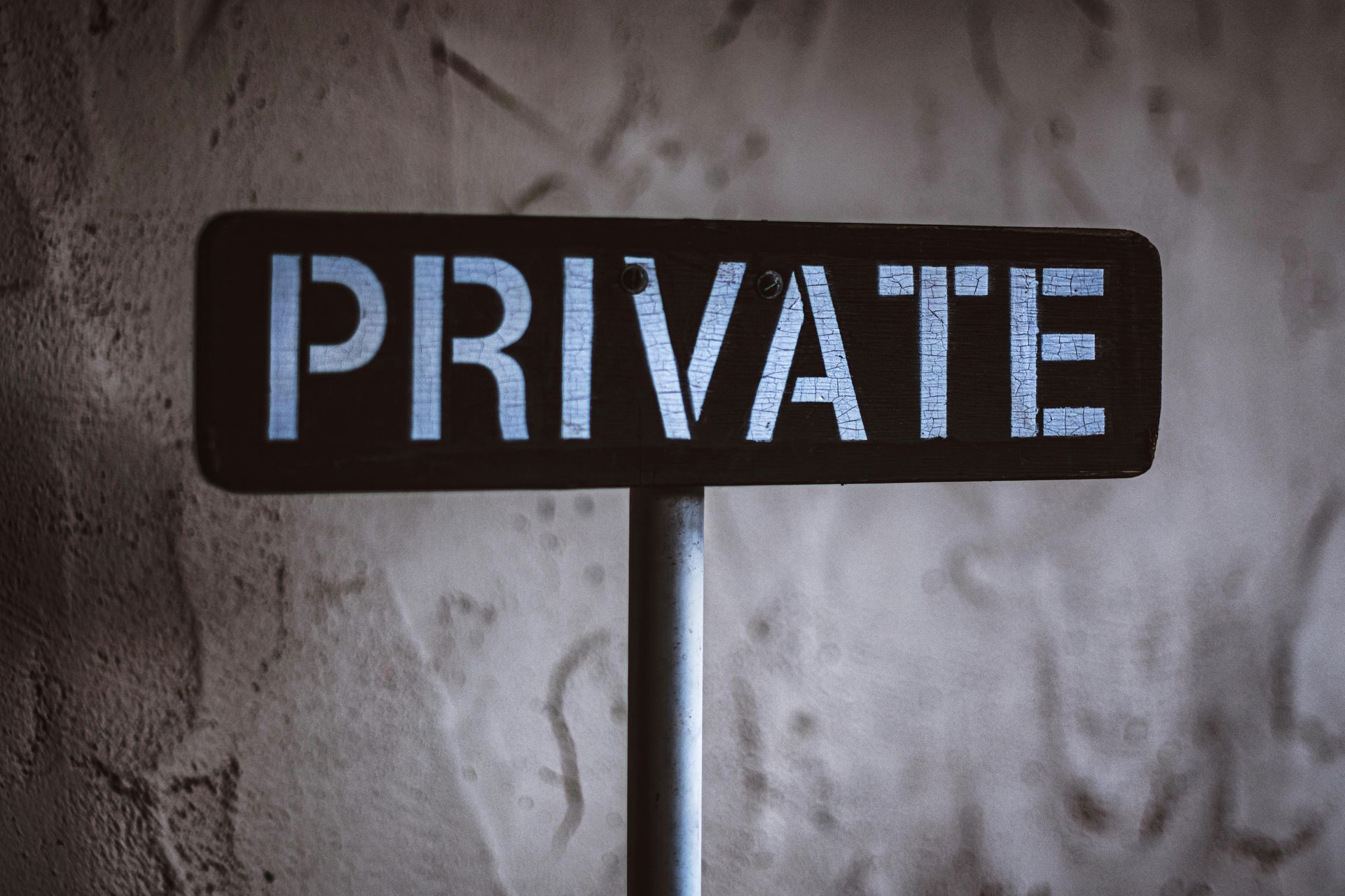 A sign that says `` private '' is sitting in front of a wall.