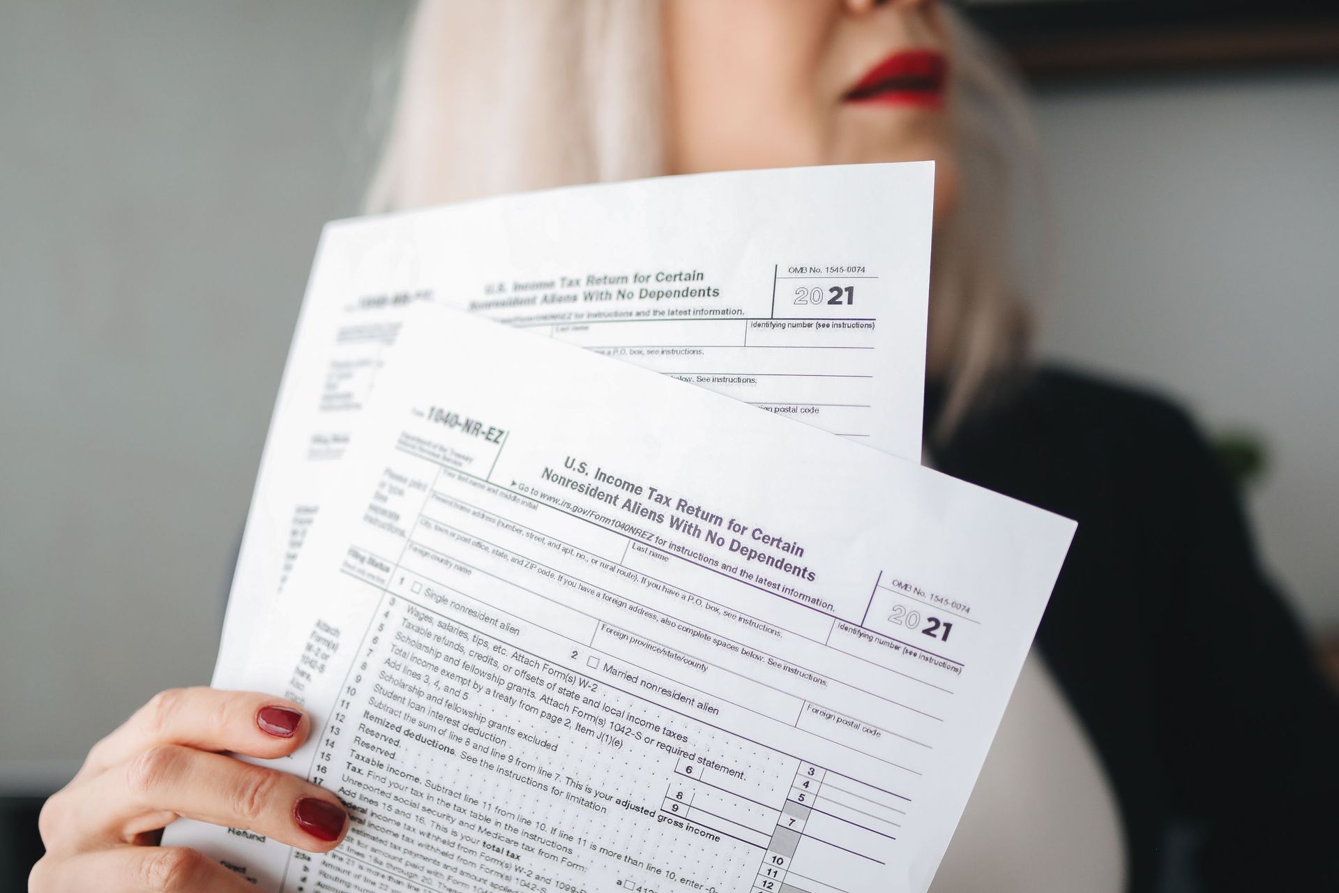 Person holding two printed documents in front of their face