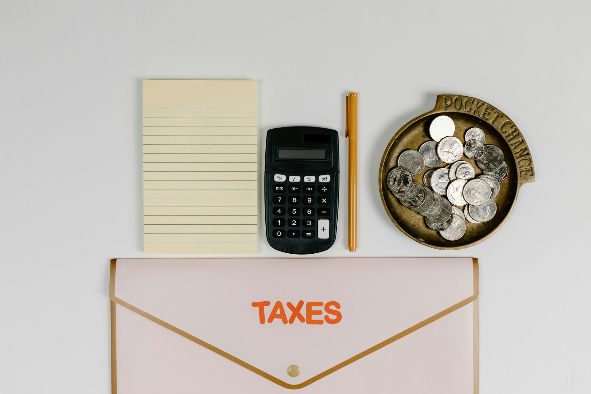 Tax documents with calculator, pencil, coin bowl, and envelope labeled “TAXES”