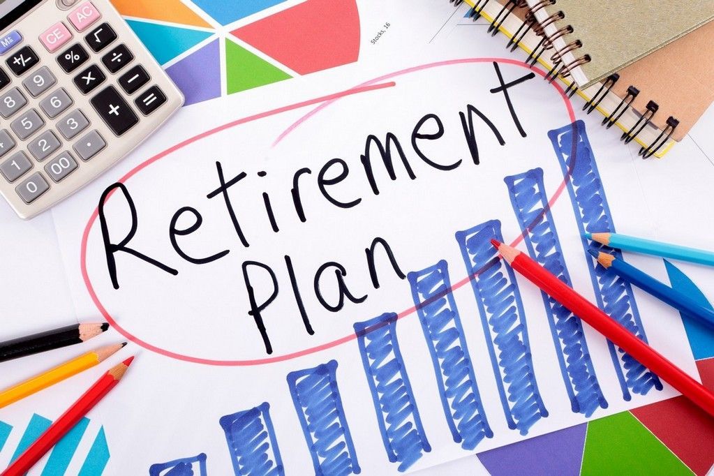 A retirement plan is written on a piece of paper next to a calculator and pencils.