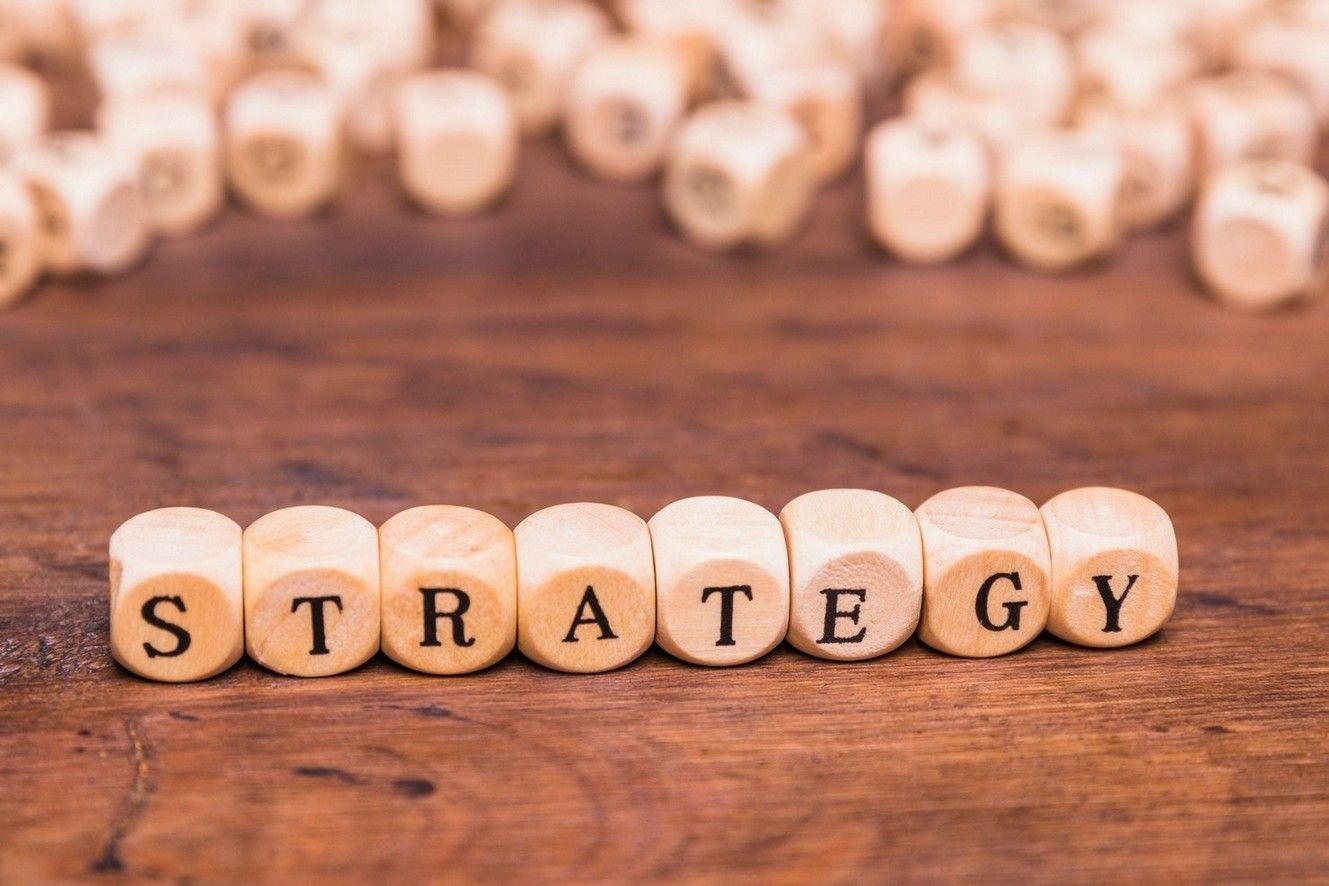 The word strategy is written on wooden cubes on a wooden table.