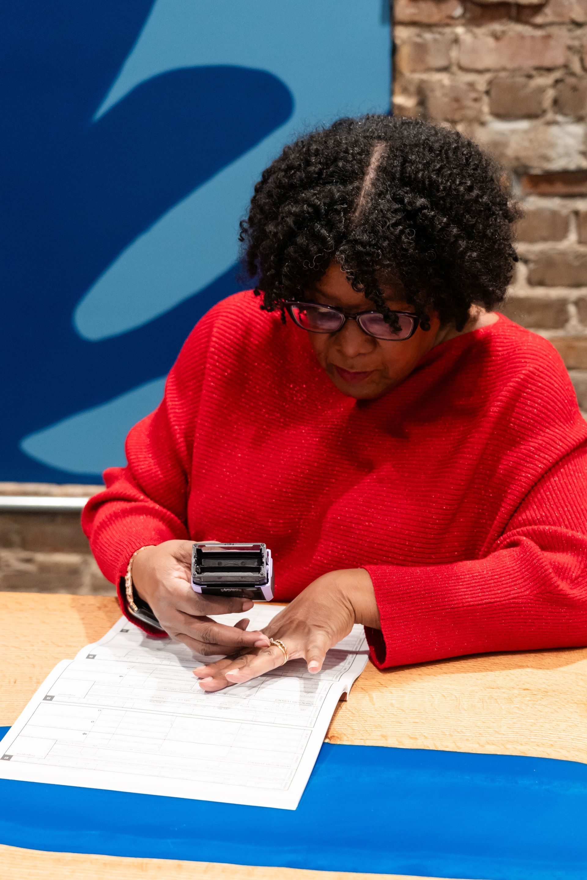 A person is pointing at a piece of paper on a table.