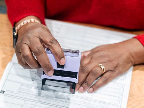 A woman is stamping a document with a stamp