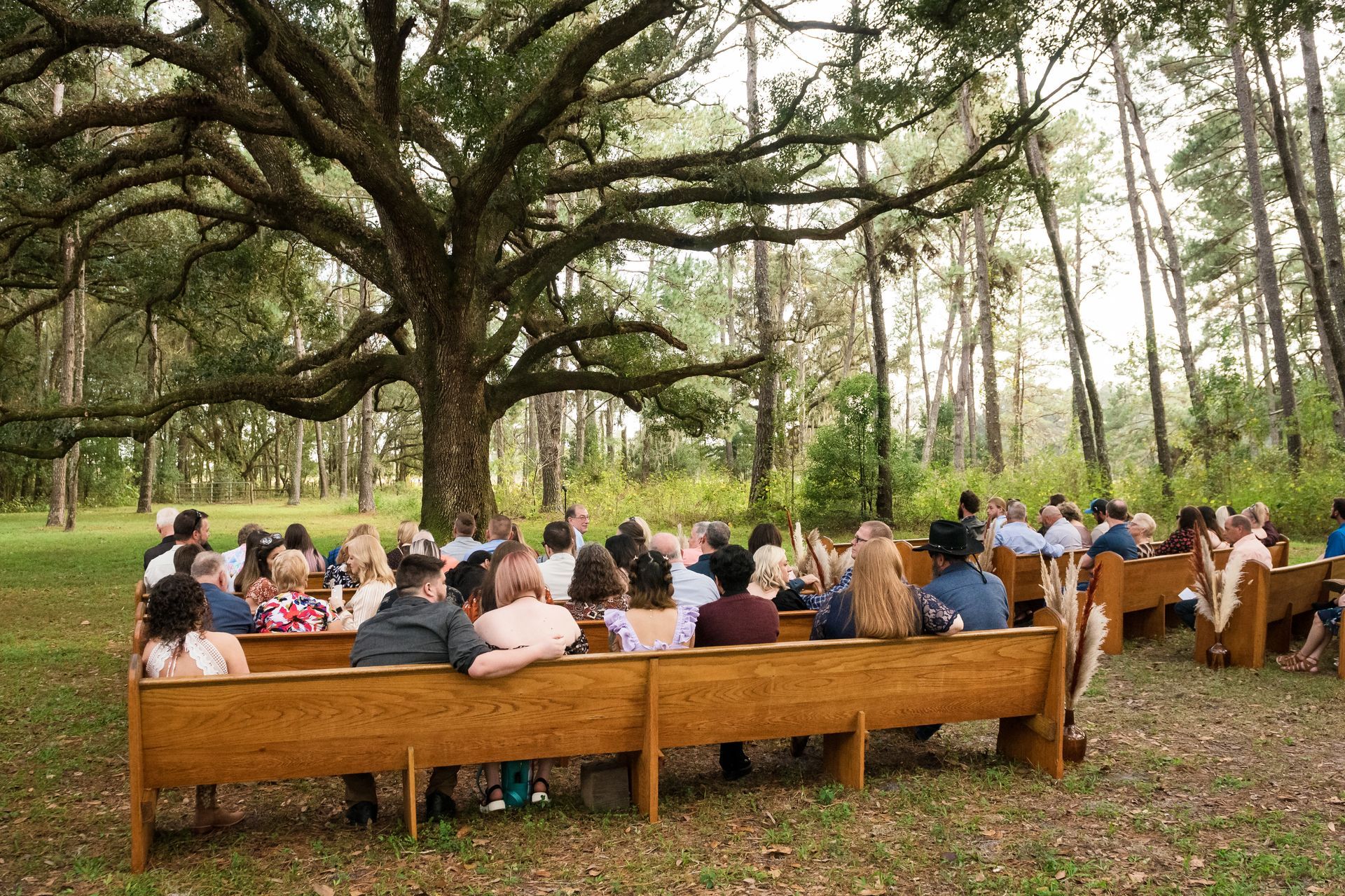 A bride and groom are holding hands and the groom is putting a wedding ring on the bride 's finger.