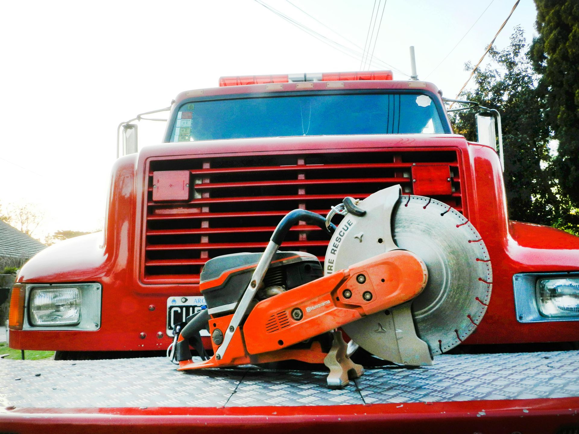 Red truck with a circular saw on its front.