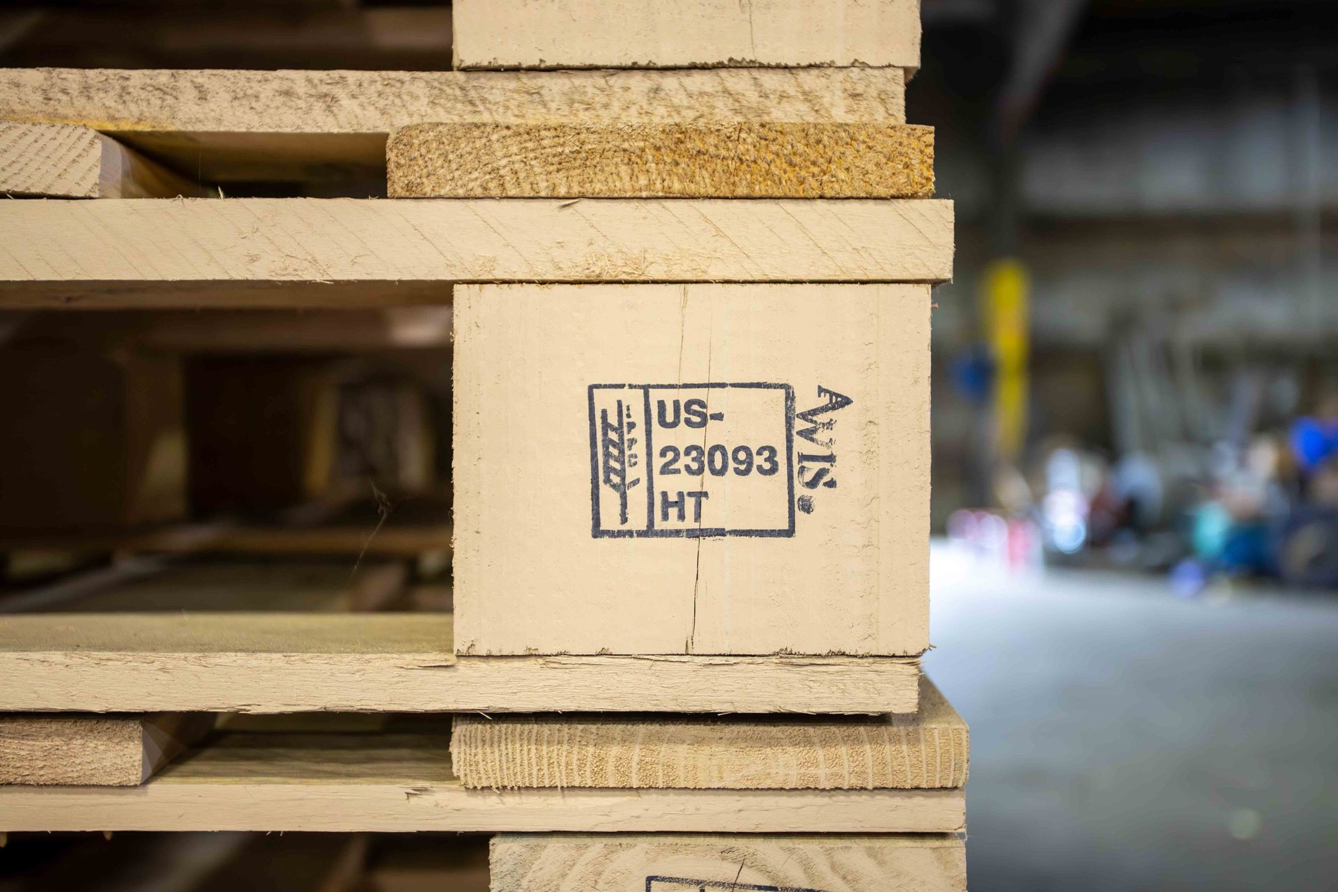 A close up of a stack of wooden pallets in a warehouse.