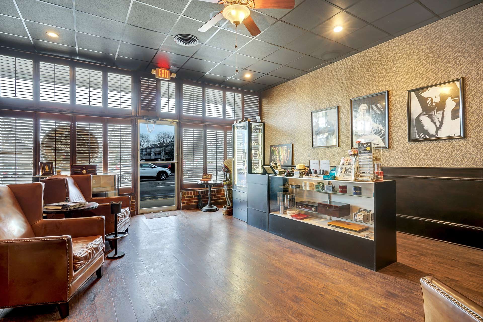 A large room with a lot of windows and a ceiling fan