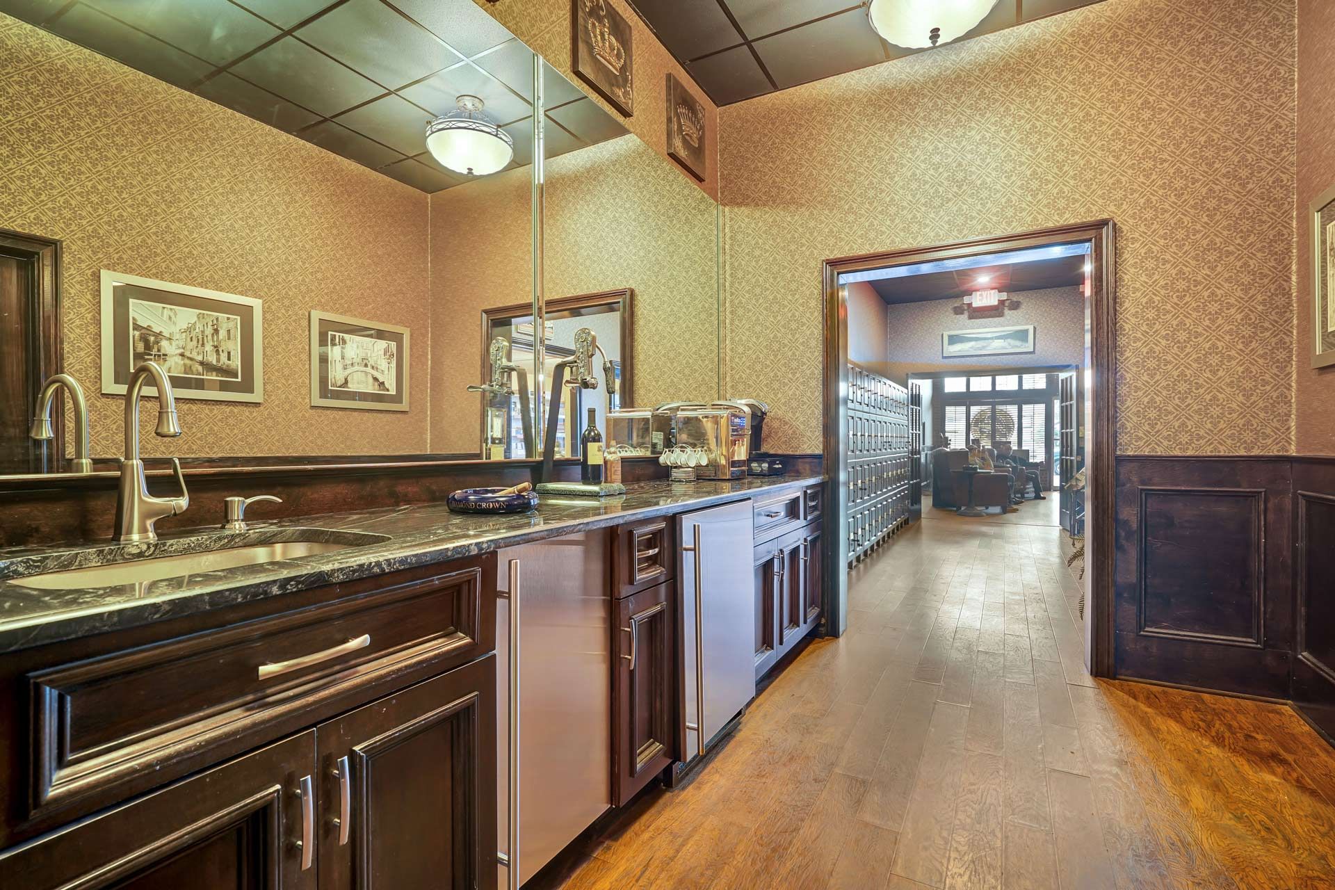 A kitchen with a sink, refrigerator, and a large mirror